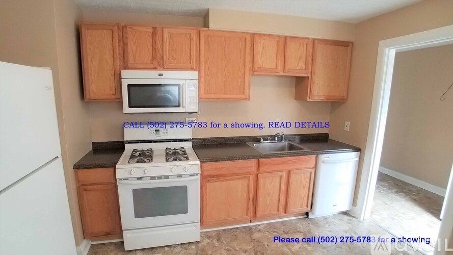 A kitchen with wooden cabinets and a white stove top oven.