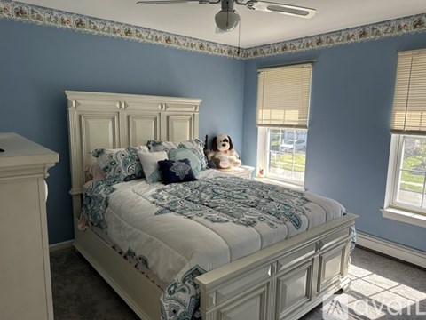 A bedroom with a large bed and a dog on the bed.