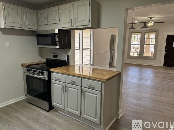 A kitchen with a wooden countertop and stainless steel appliances.