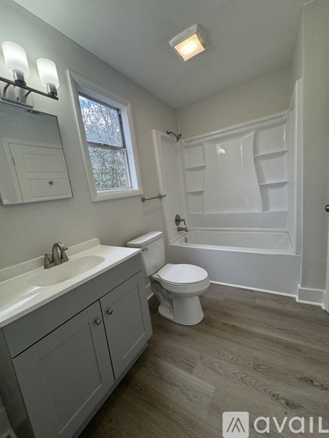 A bathroom with a toilet, sink, and bathtub.