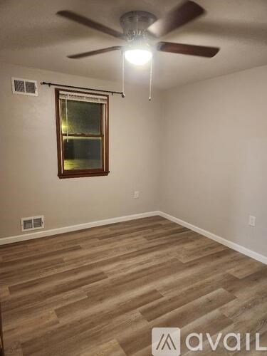 A room with a ceiling fan and a window.