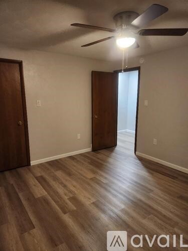 A room with wooden floors and a ceiling fan.
