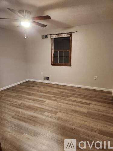A room with wooden flooring and a ceiling fan.