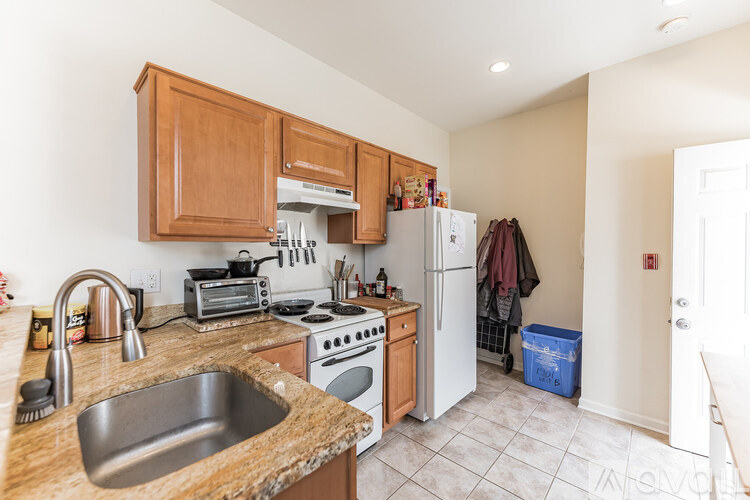 A kitchen with a refrigerator, sink, and stove.