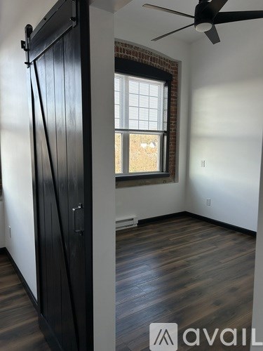 A room with a black door and a ceiling fan.