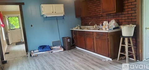 A kitchen with blue walls and wooden cabinets is under renovation.