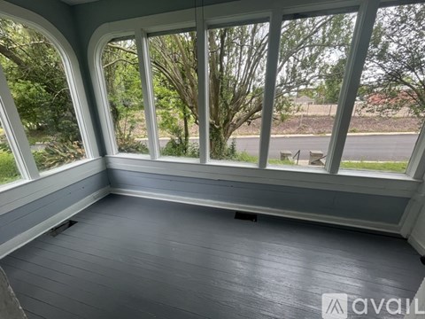 A room with a view of trees through the windows.