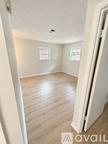 A room with wooden flooring and white walls.
