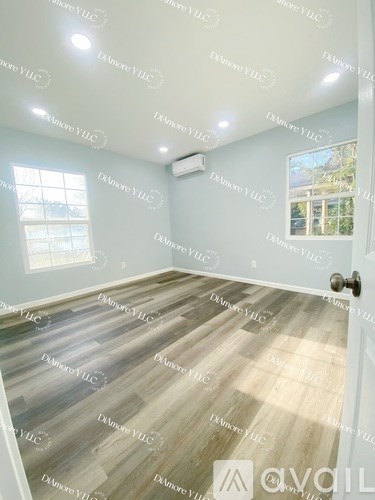 A room with wooden flooring and a window.