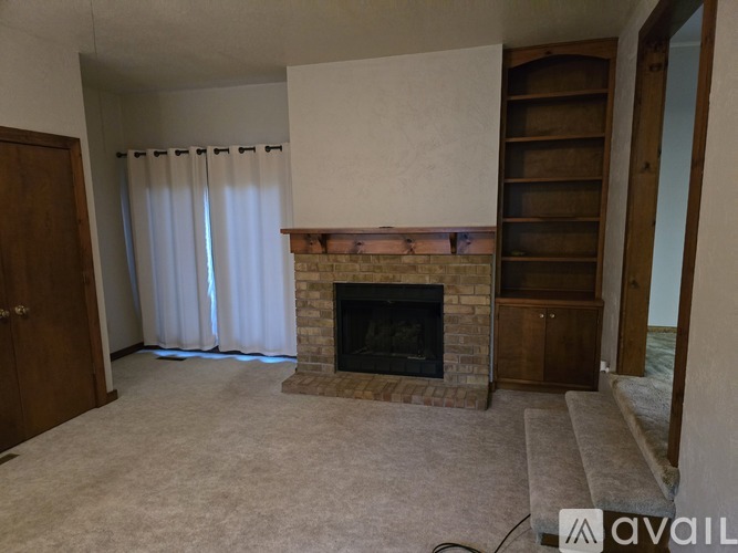 A living room with a fireplace and a sliding door.