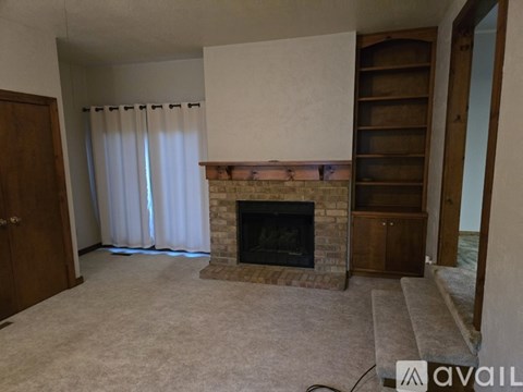 A living room with a fireplace and a sliding door.