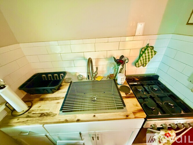 A kitchen with a white stove top oven and a green cutting board on the counter.