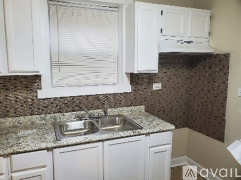 A kitchen with granite countertops and white cabinets.