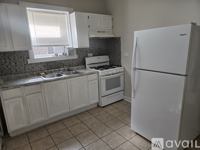 A kitchen with a granite countertop and white cabinets.