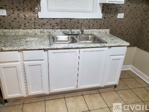 A kitchen with a granite countertop and white cabinets.