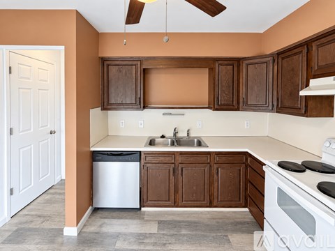 A kitchen with brown cabinets and a white stove top oven.
