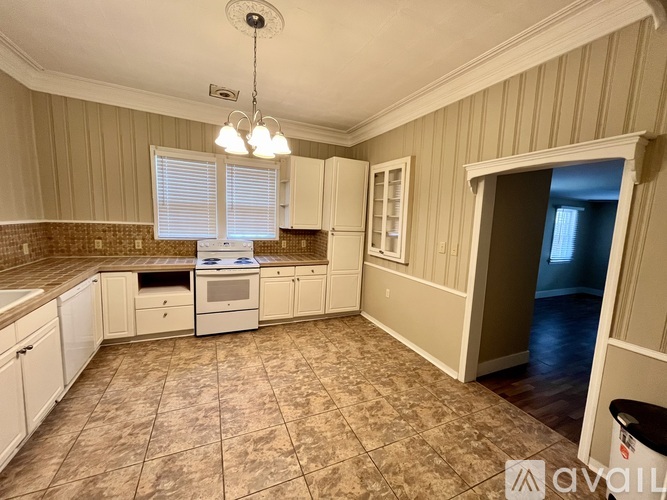 A kitchen with beige cabinets and a tiled floor.