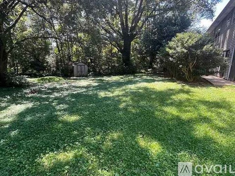 A backyard with a well-maintained lawn and trees.