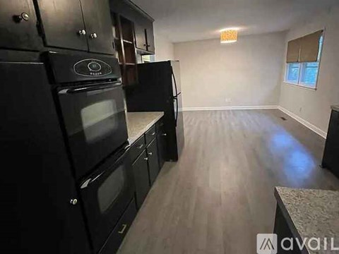 A kitchen with black appliances and wooden cabinets.