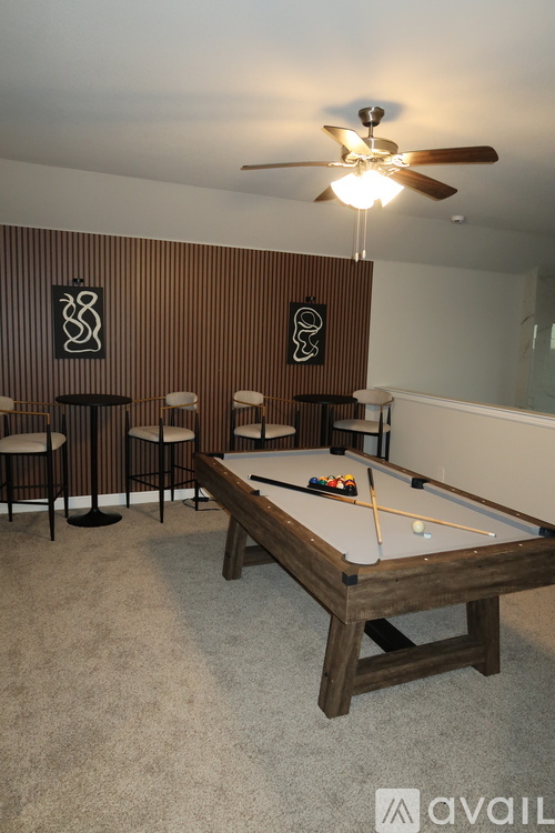 A pool table with a light on the ceiling and a wall with a striped pattern.