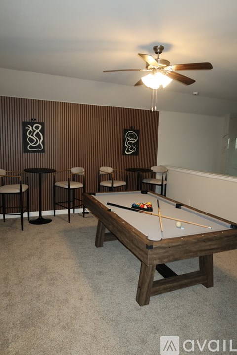 A pool table with a light on the ceiling and a wall with a striped pattern.