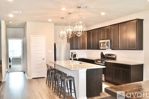 A kitchen with dark brown cabinets and a white island.