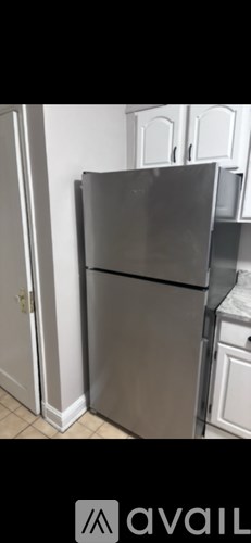 A stainless steel refrigerator stands in a kitchen.