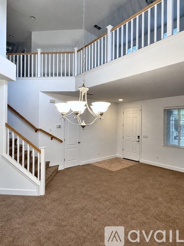 A large open space with a staircase and a chandelier.
