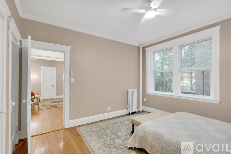 A bedroom with a bed, a window, and a fan.