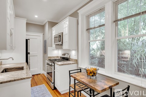 A kitchen with a table and chairs by the window.