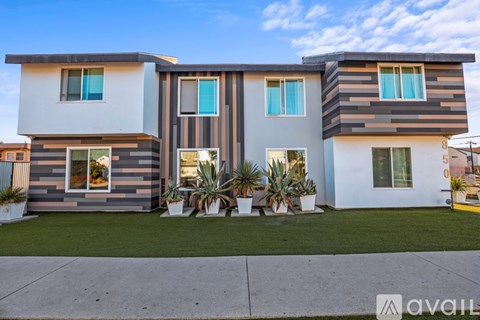 A modern two-story house with a front yard and landscaping.