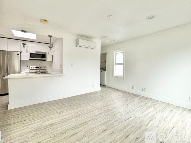 A kitchen with white cabinets and a stainless steel refrigerator.