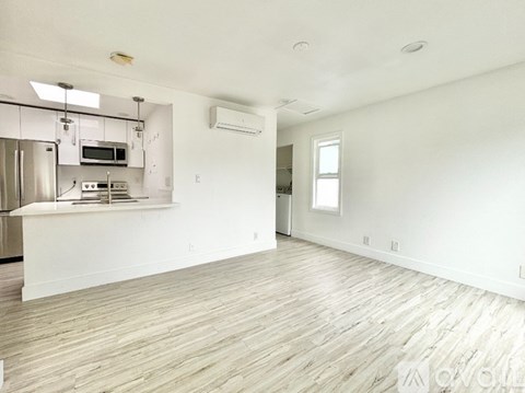 A kitchen with white cabinets and a stainless steel refrigerator.