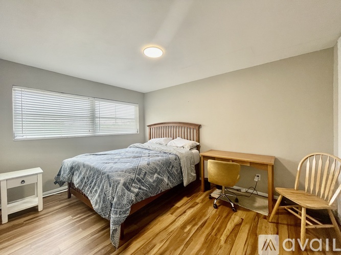 A bedroom with a bed, desk, and chair.