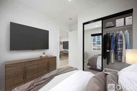 A bedroom with a large bed and a wardrobe with clothes hanging on it.