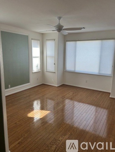 A room with wooden floors and a ceiling fan.