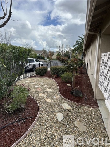 A white car is parked in a driveway.