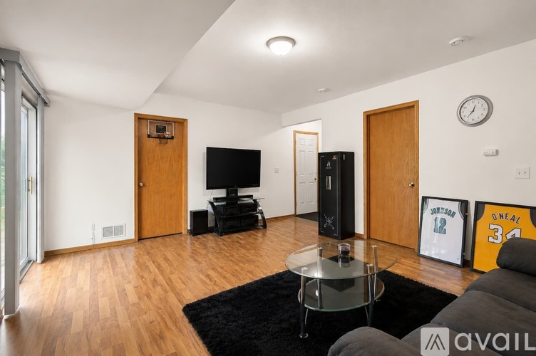 A living room with a glass coffee table and a TV.