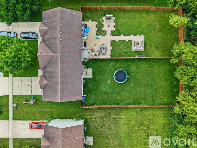 A bird's eye view of a backyard with a swimming pool and a tall brown building.