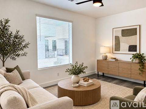 A living room with a couch, a coffee table, and a painting on the wall.