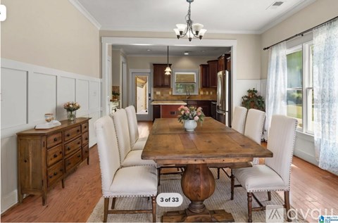 A dining room with a wooden table and chairs.