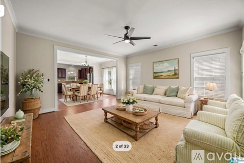 A living room with a wooden floor and a ceiling fan.