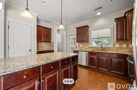 A kitchen with brown cabinets and a granite countertop.