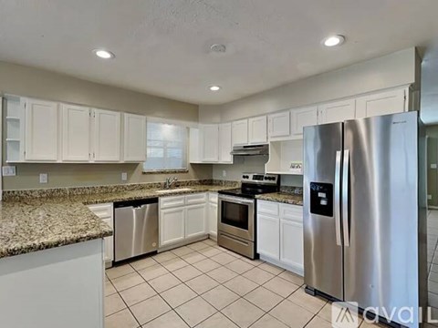 A kitchen with white cabinets and a granite counter top.