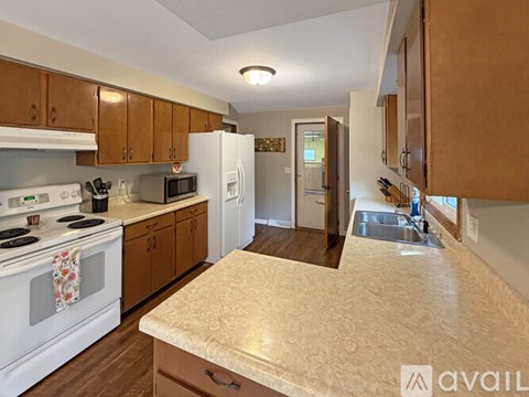 A kitchen with a white stove top oven and a white refrigerator.