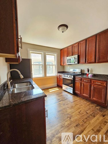 A kitchen with wooden cabinets and a black countertop.