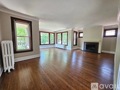 A living room with hardwood floors and a fireplace.