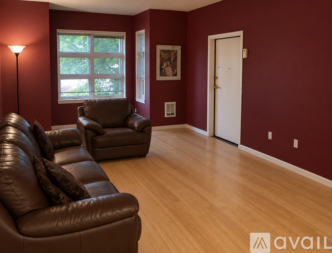 A living room with brown leather furniture and a white door.