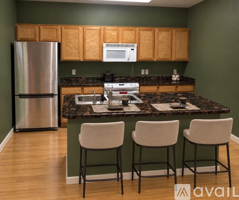 A kitchen with a granite countertop and stainless steel appliances.