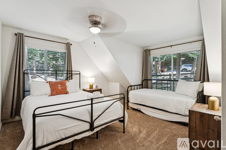 A bedroom with two beds and a ceiling fan.